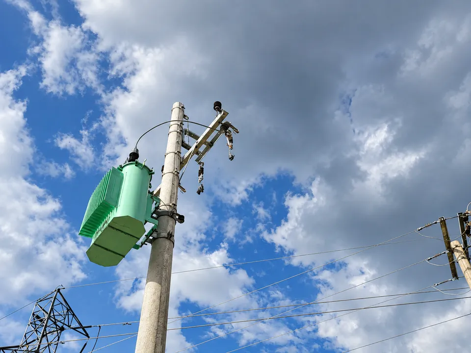 Transformador instalado em poste de concreto, com estruturas e condutores de distribuição